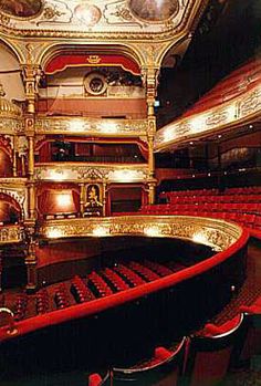 an auditorium with red seats and gold trim