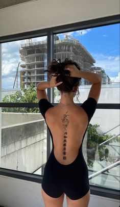 the back of a woman's body in a black swimsuit with chinese writing on it