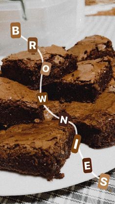 chocolate brownies on a plate with the words brownie spelled out in small letters