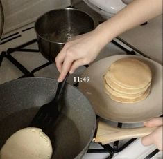 a person cooking pancakes in a pan on the stove