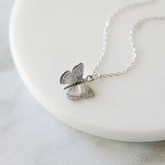 "Beautiful and lovely tiny butterfly necklace in silver color. Made of matte-finished dainty butterfly pendant with rhodium-plated skinny brass chain. Soft and warm. Great for gift, everyday or special occasion. Your item will ship in a gift box. Please feel free to contact me if you have any questions. ♥ Length 14\" - 20\" ♥ Pendant 1/2\" x 3/8\" ♥ Rhodium plated over brass ♥ See more Rudiana Accessories Rudiana.etsy.com" Silver Butterfly Necklace For Birthday, Silver Necklaces With Delicate Chain For Birthday, Sterling Silver Charm Necklace With Delicate Chain For Birthday, Silver Delicate Chain Necklace For Birthday, Silver Necklace With Delicate Chain For Birthday, Personalized Silver Butterfly Necklace, Dainty Sterling Silver Charm Necklaces With Butterfly Charm, Silver Butterfly Necklace With Delicate Chain, Silver Delicate Butterfly Necklace With Delicate Chain