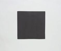 a piece of black paper on a white surface