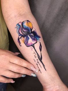 a woman's arm with a flower tattoo on it