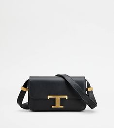 With an essential design, this micro flap bag is characterized by a pressure T Timeless buckle. Crafted in refined calfskin leather, it comes with a practical front pocket concealed by the flap. The shoulder strap is adjustable by branded metal sliders, while a saddlery-style stitching peaks at the sides in the distinctive T-stitching. A unisex model that fully combines traditional craftsmanship and contemporary elegance. Classic Tan Calf Leather Shoulder Bag, Luxury Tan Flap Bag With Removable Pouch, Timeless Tan Shoulder Bag For Office, Timeless Tan Business Shoulder Bag, Modern Tan Flap Bag With Gold-tone Hardware, Timeless Tan Shoulder Bag For Evening, Timeless Tan Shoulder Bag With Branded Hardware, Classic Tan Leather Flap Bag, Classic Tan Flap Bag For Evening