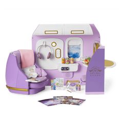 a doll house with furniture and accessories including a purple chair, sink, and refrigerator