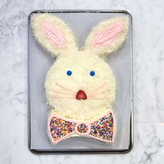 a cake in the shape of a bunny wearing a bow tie with sprinkles