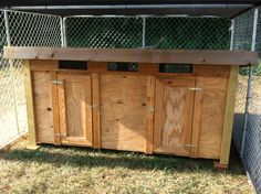 a chicken coop with three doors on the side and one door open to reveal something inside