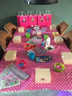 the table is covered with pink and white polka dot paper bags, wooden boxes, and other crafting supplies