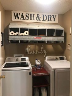 a washer and dryer sitting next to each other in a room with a sign above it