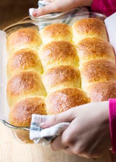 a person holding a glass dish filled with bread