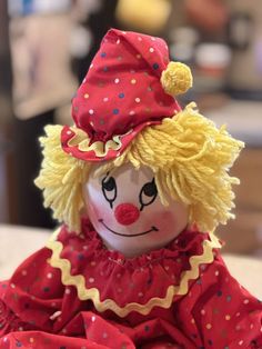 a red and yellow clown doll sitting on top of a table