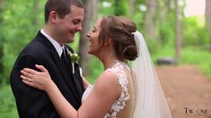 a bride and groom standing together in the woods