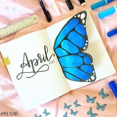 an open notebook with the word april written on it next to some markers and pencils