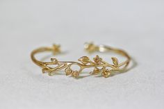 This dainty and beautiful floral bracelet is made out of some entwined branches, a few tiny little flowers and some leaves. This piece is flexible and easy to adjust. It has two tiny flowers sealing each side of the open part, which means you could wear it either facing up or down. * Comes wrapped in a beautiful gift package. * Could be worn on both sides, facing up or down. * Could be requested in either 14k gold, rose gold or silver plated brass. For updates, new products, one-of-a-kind's, spe Bohemian Wedding Bracelets With Flower Shape, Charming Adjustable Jewelry For Wedding, Nature-inspired Wedding Bracelet Jewelry, Nature-inspired Wedding Bracelet, Gold Flower Bracelet, Branch Bracelet, خواتم خطوبة, Bridal Necklace Designs, Ankle Jewelry