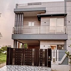 the front view of a two story house with an iron gate and decorative tile on the ground