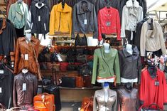 an assortment of leather jackets and handbags for sale