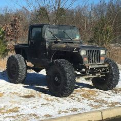 the jeep is parked on the side of the road in front of some trees and grass