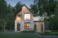 a rendering of a house in the woods at night with lights on and windows lit up