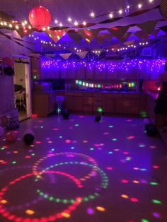 a party room with disco lights and colorful circles on the dancefloored floor