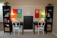 two white chairs sitting in front of a black table with red, green and blue chairs