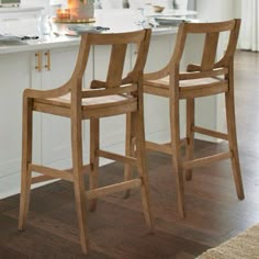 two wooden bar stools sitting in front of an island