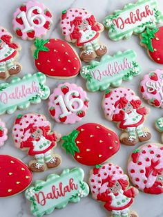 some decorated cookies are sitting on a table with the names and numbers painted on them