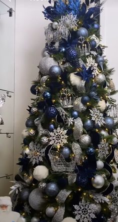 a christmas tree decorated with blue and silver ornaments