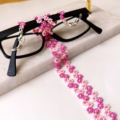 This handmade pink flower glasses chain is carefully hand-woven from the highest quality glass seed beads! Lenght 70 cm ( 27 inches ) It is not only a sweet sunglasses chain, but also a multi-purpose flower glasses chain that you can use as a daisy long necklace, wrap bracelet, cute reading glasses! It is an eyewear cord that is compatible with all your clothes that you can use in all seasons! Guaranteed to get all the compliments! It is the ideal handmade gift jewelry and accessory for you and Handmade Adjustable Pink Glasses Chains, Handmade Pink Glasses Chains For Summer, Adjustable Pink Glasses Chains As Gift, Adjustable Pink Beaded Glasses Chain, Pink Glass Glasses Chains For Summer, Elegant Pink Glasses Chain As Gift, Elegant Pink Glasses Chain Gift, Handmade Pink Glass Glasses Chains, Adjustable Pink Glass Glasses Chains