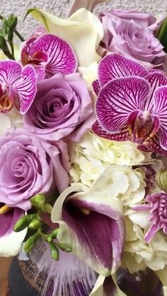 a vase filled with purple and white flowers