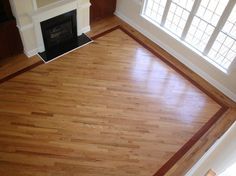 an empty living room with hard wood floors and a fireplace in the corner, viewed from above