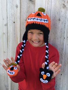 a young boy wearing a knitted hat and mittens