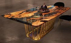 a dining table made out of wood and metal with a bottle on the top, next to two chairs