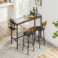 a kitchen table with two stools and a wine bottle on it in front of a window