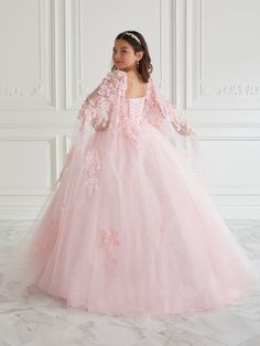 Your sweet girl will love twirling around in this 3D floral applique long sleeveless cape sleeve dress with A-line skirt by Tiffany Princess 13669. This sleeveless V-neck ball gown features detachable cape sleeves, 3D floral appliques throughout the bodice, A-line sparkle tulle skirt, and a lace-up back. House of Wu Tiffany Princess Collection Spring 2022 Style Number: 13669 Fabric: 3D Floral Appliques/ Sparkle Tulle Please note: There may be a loss of glitter while wearing this dress due to the Princess Style Long Sleeve Dress For Debutante Ball, Princess Style Dress With Floral Applique For Debutante Ball, Princess Dress With Floral Applique For Debutante Ball, Princess Style Floral Applique Dress For Debutante Ball, Pink Long Sleeve Dress For Debutante Ball, Pink Long Sleeve Pageant Dress, Pink Gown With Cape Sleeves, Spring Princess Quinceanera Dresses, Long Sleeve Floral Applique Prom Dress