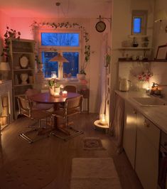 a dining room table and chairs in front of a window with candles on the windowsill