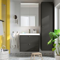 a bathroom with grey cabinets and yellow accents