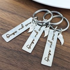 four personalized key chains with angel wings on them