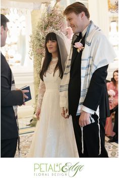 a man and woman standing next to each other in front of a wedding ceremony arch