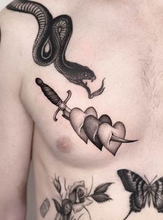 a man's chest with tattoos on it and a snake holding a knife in the middle