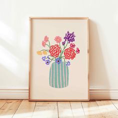 an art print with flowers in a striped vase on a wooden floor next to a white wall