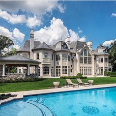 a large house with a pool in the front yard and lawn furniture on the other side