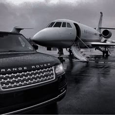 a range rover parked next to an airplane on the tarmac