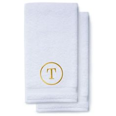 two white towels with the letter t in gold on them, one has a monogrammed