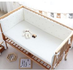 a baby crib with a stuffed animal on the floor next to it's bed