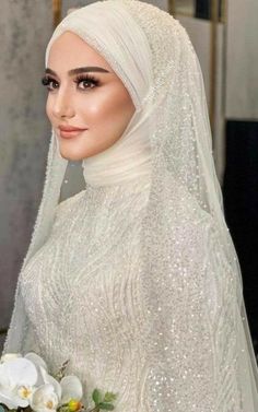 a woman wearing a white veil and dress