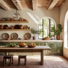 a table with bowls and plates on top of it in front of an arched window