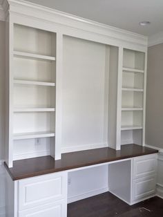 an empty room with built in bookshelves and cabinets