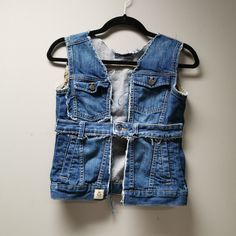 a blue jean vest hanging on a wall