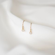 Simple and perfect for everyday wear, these dainty earrings feature a 3mm brilliant dangling cubic zirconia charm. These are all made of 14K gold filled materials and are tarnish-resistant, water-resistant, and hypoallergenic.  Comes with box and jewelry pouch, ready for gifting. --------------------♥ PROMOS ♥-------------------- Want 10% off? Join the mailing list by visiting http://bit.ly/vedern . Just leave me a note at checkout if you have any problems applying discount codes. --------------------♥ BUY WITH CONFIDENCE ♥-------------------- Don't love it? Message me to set up a return or exchange. If you find any problems with your items, just send a message with a photo, and a new one will be on its way to you! --------------------------♥ PACKAGING ♥--------------------------- Gold fil Minimalist Diamond Drop Earrings, Dainty 14k Yellow Gold-filled Earrings, Dainty 14k Yellow Gold Filled Earrings, 14k Gold Diamond Earrings With Ear Wire As Gift, Tiny Gold Elegant Diamond Earrings, Dainty 14k Gold Filled Earrings For Gift, Elegant Gold Diamond Earrings, Tiny Delicate Gold-plated Earrings, Tiny Delicate Gold Plated Earrings