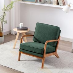 a green chair sitting on top of a wooden floor next to a white rug and table